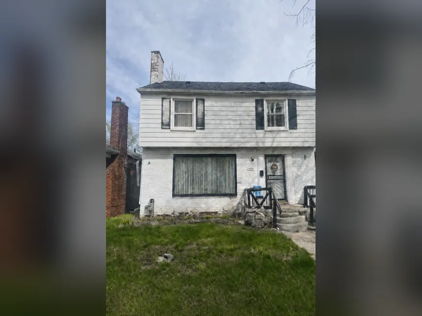 La même maison au rachat : façade peinte en blanc, perron descellé, terrain en friche